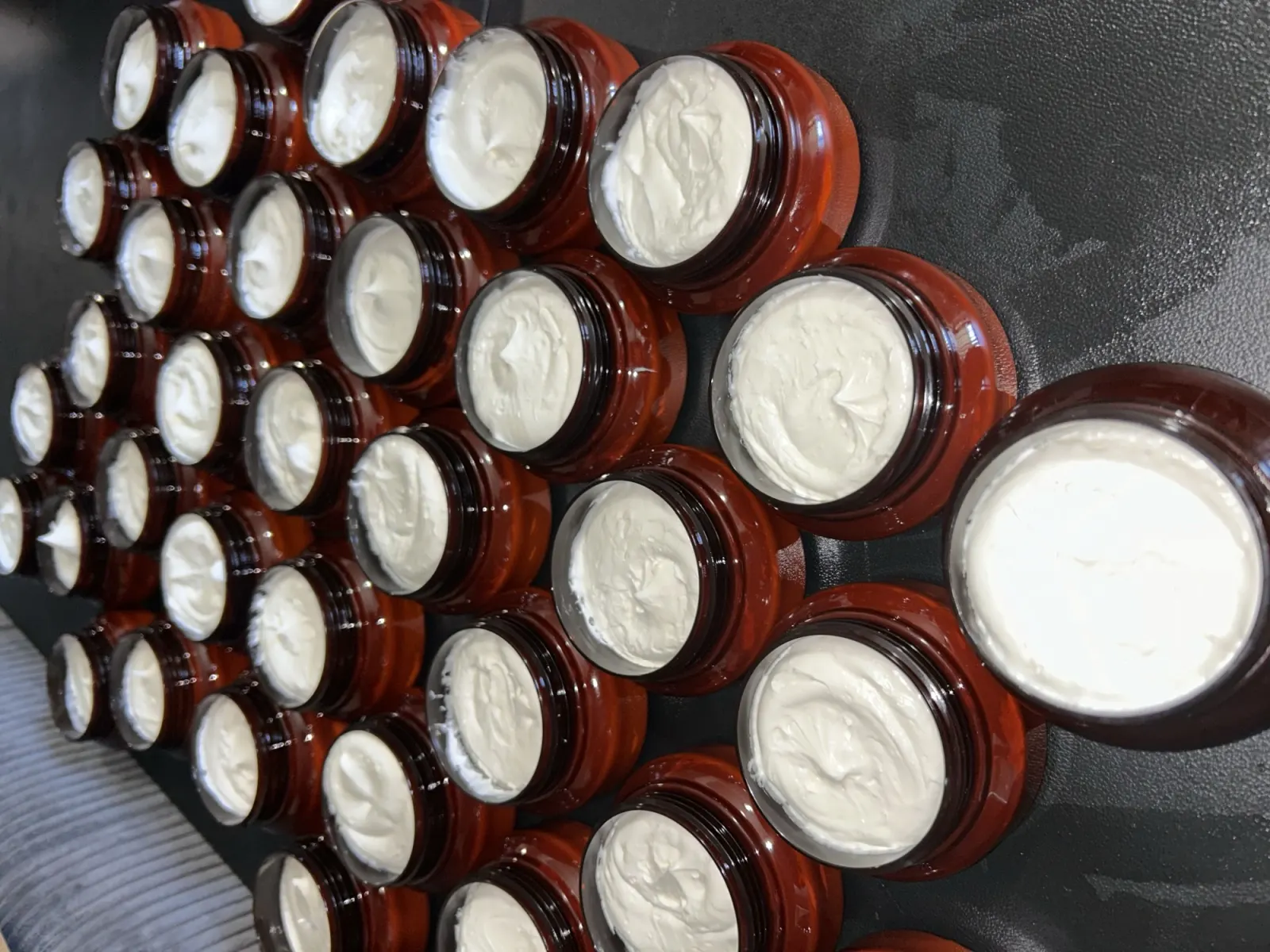 Rows of freshly filled amber jars of whipped white body butter